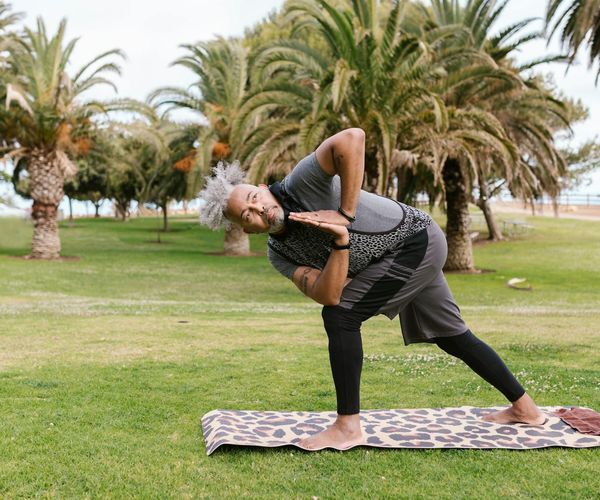 Man stretching on a mat in a peaceful setting, representing daily well-being.